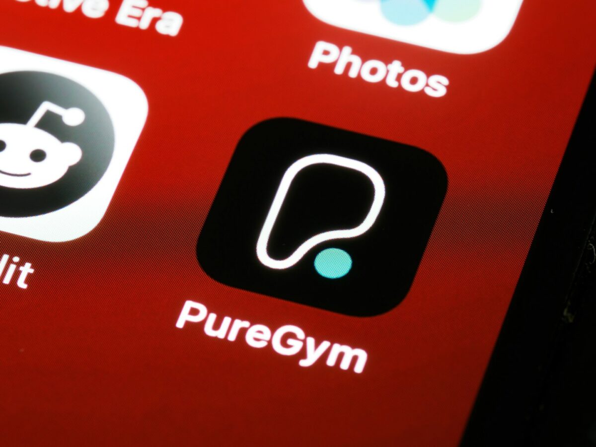 Trainer reviewing a workout app on a phone, representing the tools needed for online personal training