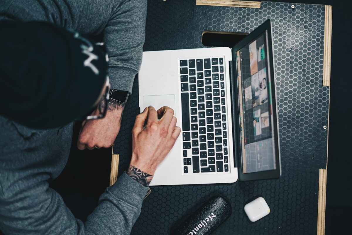 Fitness coach using a laptop in a small studio, showing a simple setup for online personal training